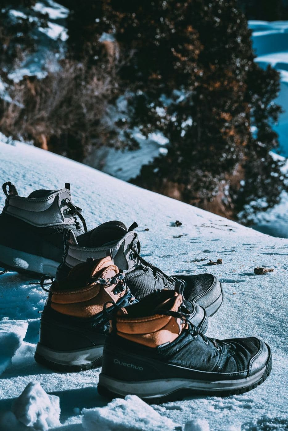 Trekking boots resting on grass with mountain peak in background after a day on the trail