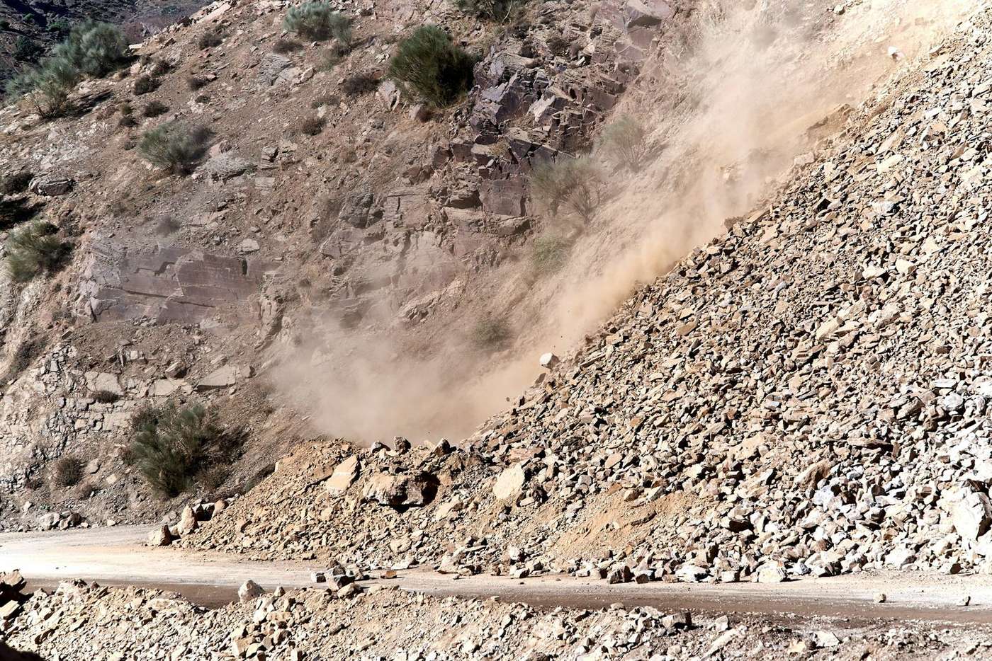 Active landslide on a mountain road in Uttarakhand during monsoon season with rocks and dust falling