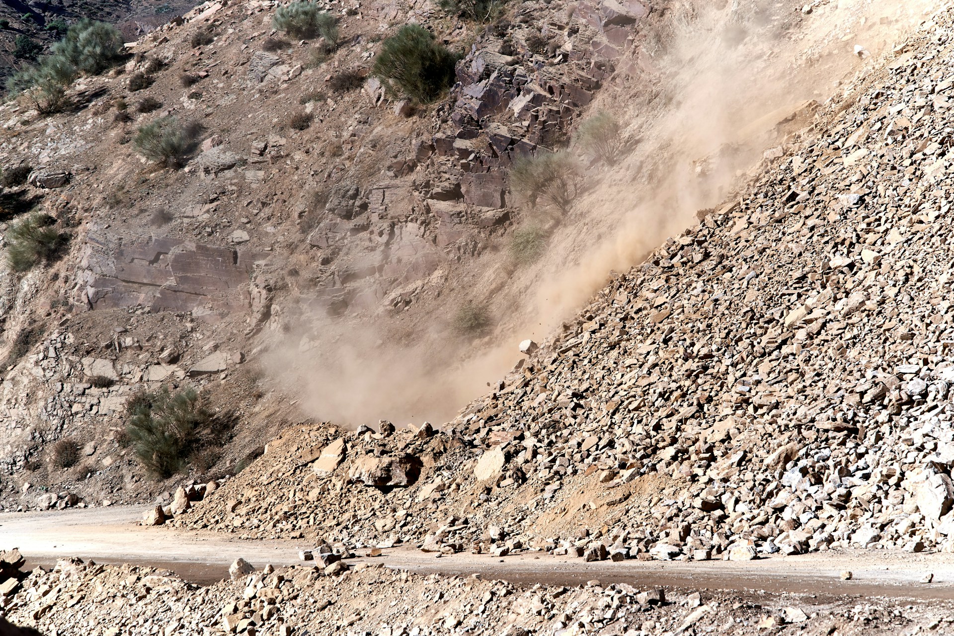 Active landslide on a mountain road in Uttarakhand during monsoon season with rocks and dust falling